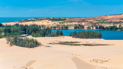 Aerial view of Bau Trang lake (a beautiful landscape, raw of automobiles with blue sky in desert, beautiful landscape of white sand dunes), the popular tourist attraction place in Mui Ne, Vietnam.