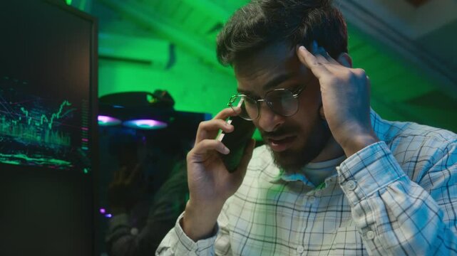 Stressed Arabian Indian man male guy looking code coder programmer technology talk mobile phone error hacker problem loss worker computer trouble IT specialist worried overwhelmed crypto currency work