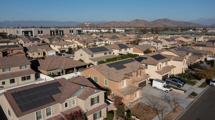 Obraz premium Afternoon sun shines on suburban homes of Jurupa Valley, California, USA.
