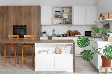 Interior of light kitchen with table, counters and cupboards