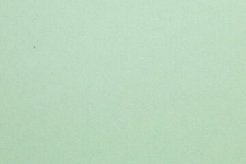A green background with a white object in the middle, textured origami paper backdrop