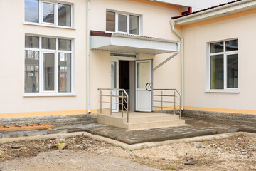Modern building entrance with metal railings and steps during renovation process