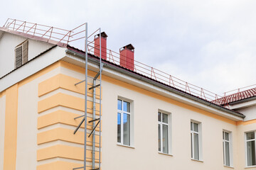 Side view of building with rooftop safety railing and exterior ladder