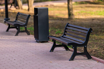 Two park benches sit on a brick walkway