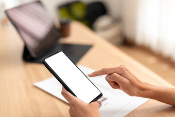 Businessman using smartphone with blank screen, working at home office