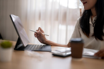 Asian businesswoman working from home using digital tablet and stylus