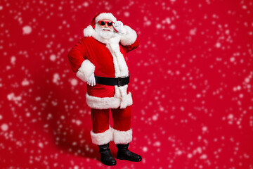 Full length body size view of nice handsome cheerful bearded Santa father St Nicholas posing touching specs festal event christmastime sale isolated bright vivid shine vibrant red color background
