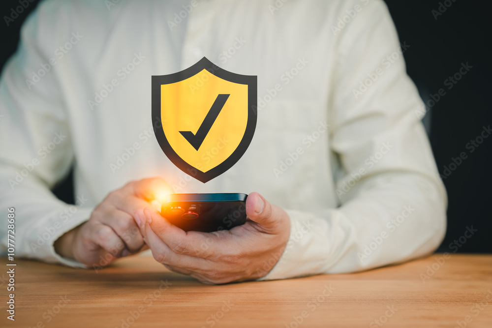 Poster Close-up of a person holding a smartphone with a glowing shield icon featuring a check mark, symbolizing mobile security, data protection, and secure online verification.