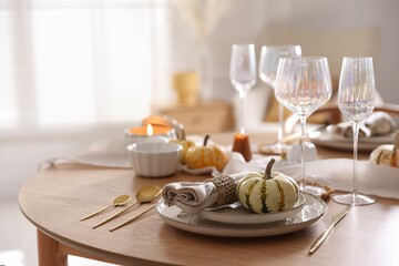 Stylish table setting with beautiful dishware and autumn decor in dining room