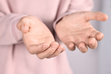 Man holding something on light background, closeup