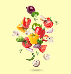 Many different fresh vegetables in air on light yellow background