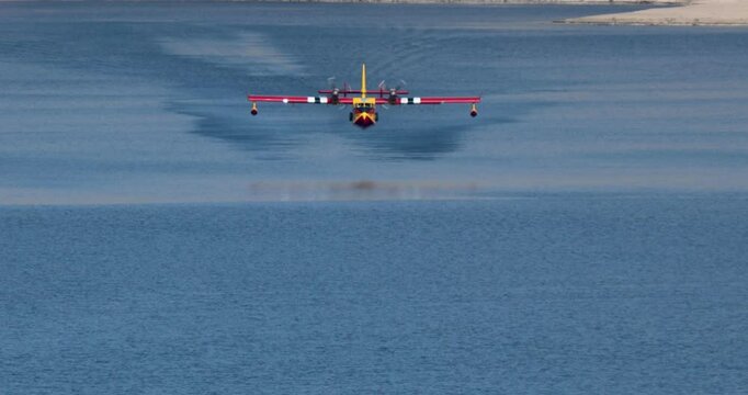 A small plane is flying over a body of water
