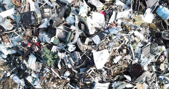 A pile of junk including a broken television and a broken refrigerator