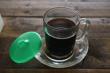 Brewed coffee on a rustic wooden table in a coffee shop (warkop)