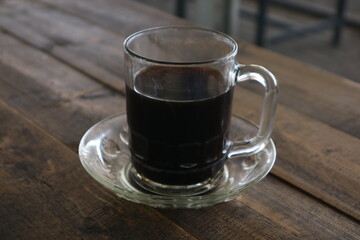 Brewed coffee on a rustic wooden table in a coffee shop (warkop)