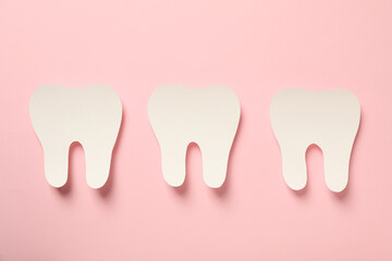 Teeth with dental tools for care, on a pink background.