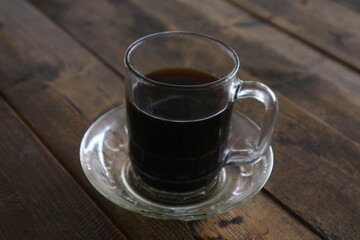 Brewed coffee on a rustic wooden table in a coffee shop (warkop)