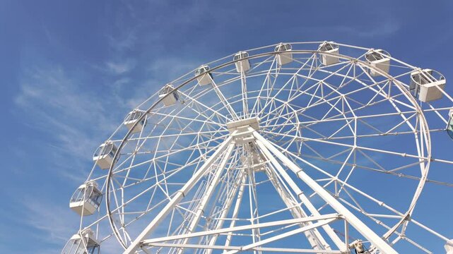 A large white Ferris wheel against a clear blue sky.