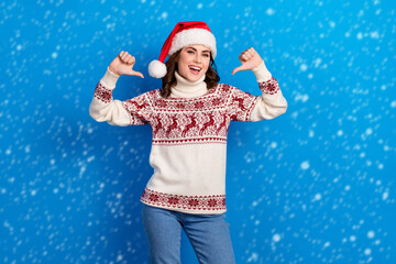 Obraz premium Photo of funny confident young girl dressed print sweater claus cap pointing thumbs herself isolated blue color background