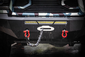 A close-up of a winch fairlead, rope, and shackles on a pickup truck designed for vehicle recovery...