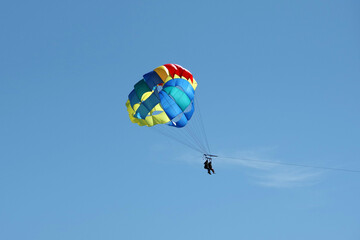 Two people parasailing high up in the sky