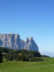 Mountain landscape with blue sky, bright green meadows, summer time in the Dolomites in Italy