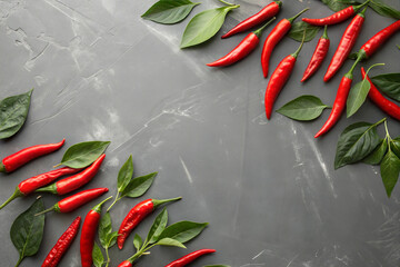 Frame made of Hot red fresh chili peppers on gray background flat lay top view. Copy space.