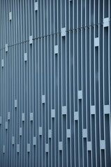 geometric facade with vertical lines and rectangular cutouts