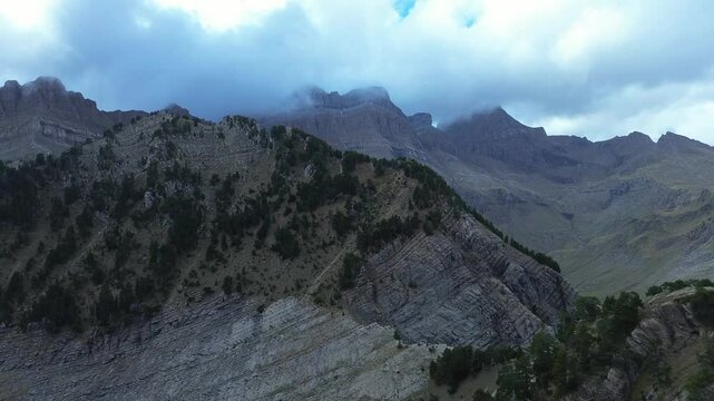Clouds drift over rugged peaks and tree-covered slopes near Collado Estiviellas, Arag&oacute;n, Spain