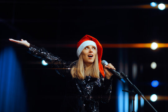 
 Cheerful Artist Singing Christmas Carols at the Microphone
Singer performing on stage in a holiday concert event 
