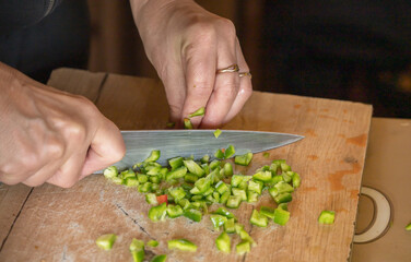 finely cutting the peppers on a wooden bell