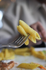 A delicious plate of Penne Pasta balanced on a fork, ready to be enjoyed and savored