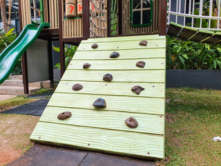 A small climbing wall with textured holds on a children playground