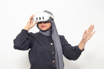 Portrait of Asian woman with hijab using virtual reality VR device, experiencing immersive technology. Isolated image on white background