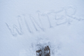 Word WINTER written in the frozen snow in winter season. Concept of cold snowy weather forecast....