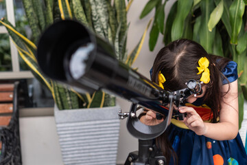 Latin girl peering closely through a telescope outdoors