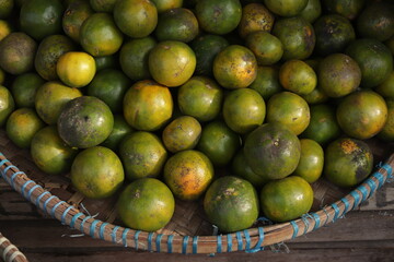 a collection of green and orange citrus fruits