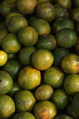 a collection of green and orange citrus fruits