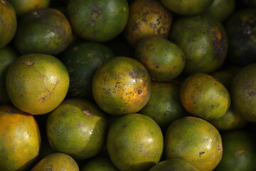 a collection of green and orange citrus fruits