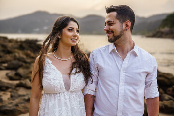 bride and groom on a beach, dressed in white for wedding, new year, party, family, young couple