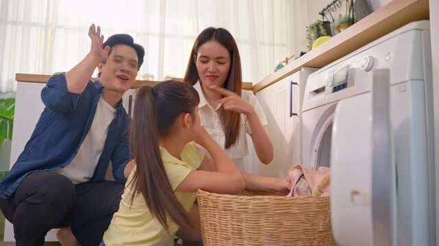 Asian family put dirty clothes to washing machine in house together.