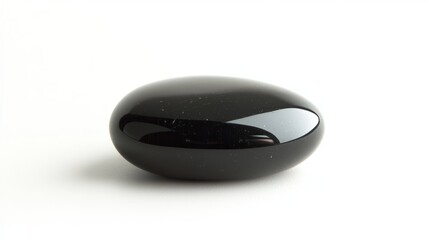 A smooth black pebble with a glossy surface, isolated on a white background
