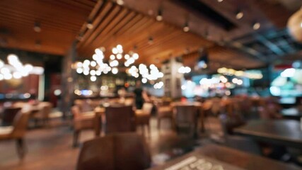 Blurred cozy stylish restaurant interior with warm ambient lighting empty tables. Soft bokeh effect highlights relaxed atmosphere perfect for social gatherings quiet moments. Food drink people