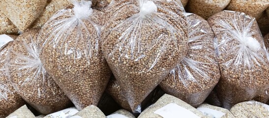 A kilogram of fried buckwheat in a transparent bag in the supermarket. Rising food prices. Cereals. Grocery store. Background.
