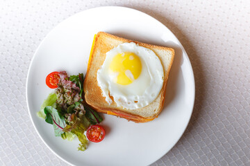 Homemade breakfast scrambled egg sandwich with tomatoes cherry on white table, healthy breakfast fried egg on toast with fresh and nutritious ingredients