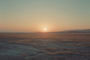 Obraz premium The morning sun peeking over the horizon in a remote area, filling the empty landscape with soft light.