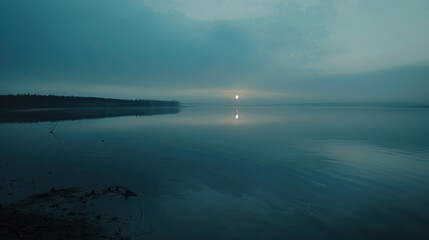 Fototapeta premium Time-lapse of a calm lake at dawn, the rising sun slowly lighting up the water's reflection as the day begins