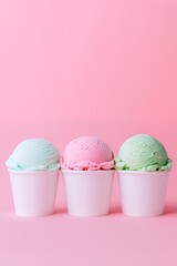 Three scoops of ice cream in white cups on pink background.