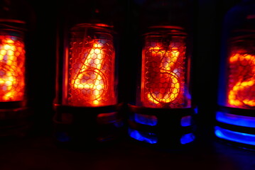 Retro Nixie lamp indicator clock on dark background. The Nixie tube indicator of the numbers of...