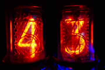 Retro Nixie lamp indicator clock on dark background. The Nixie tube indicator of the numbers of...
